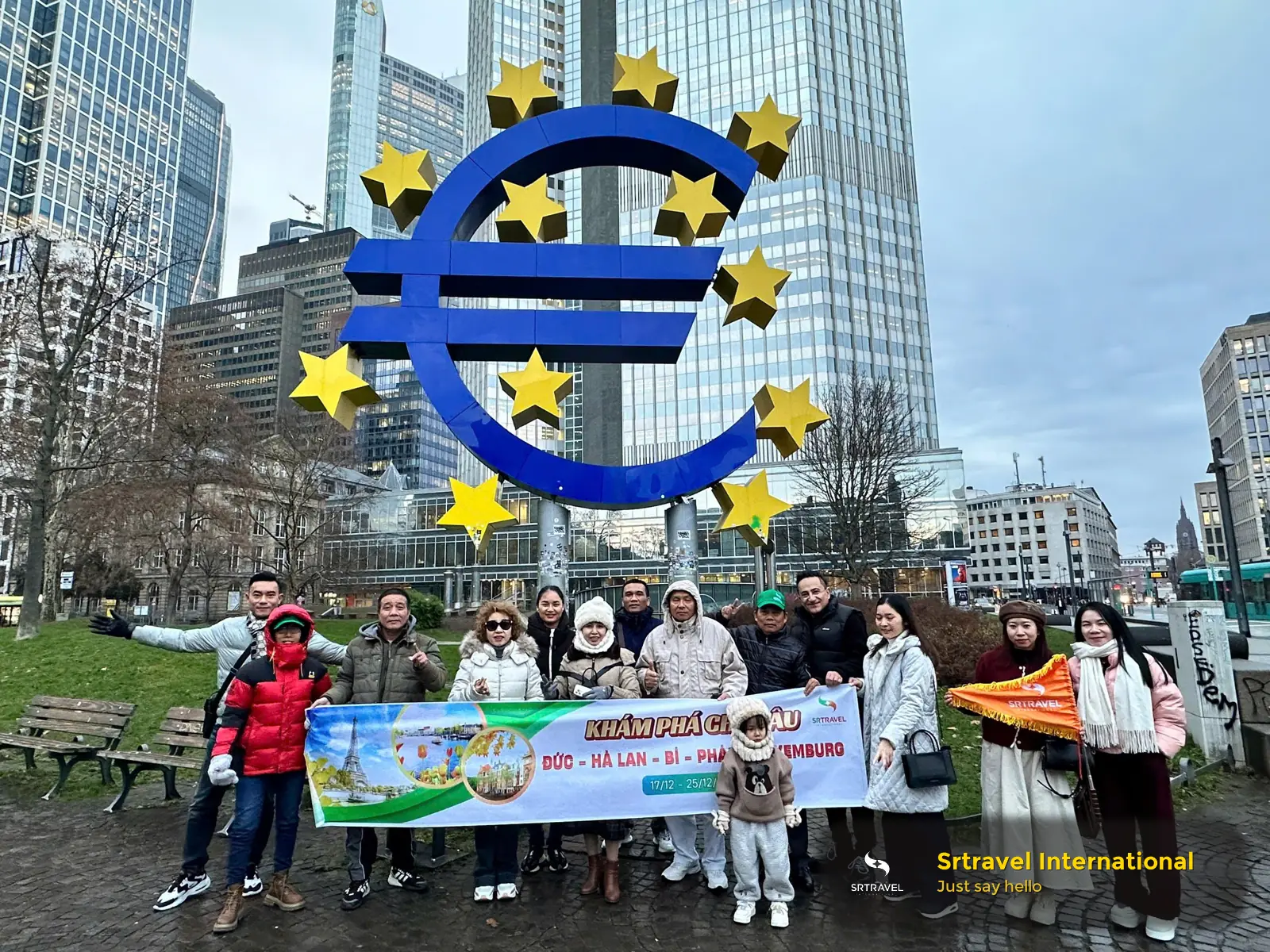 Nhóm du khách tại Frankfurt trước biểu tượng đồng Euro trong tour khám phá Đức, Hà Lan, Bỉ, Pháp