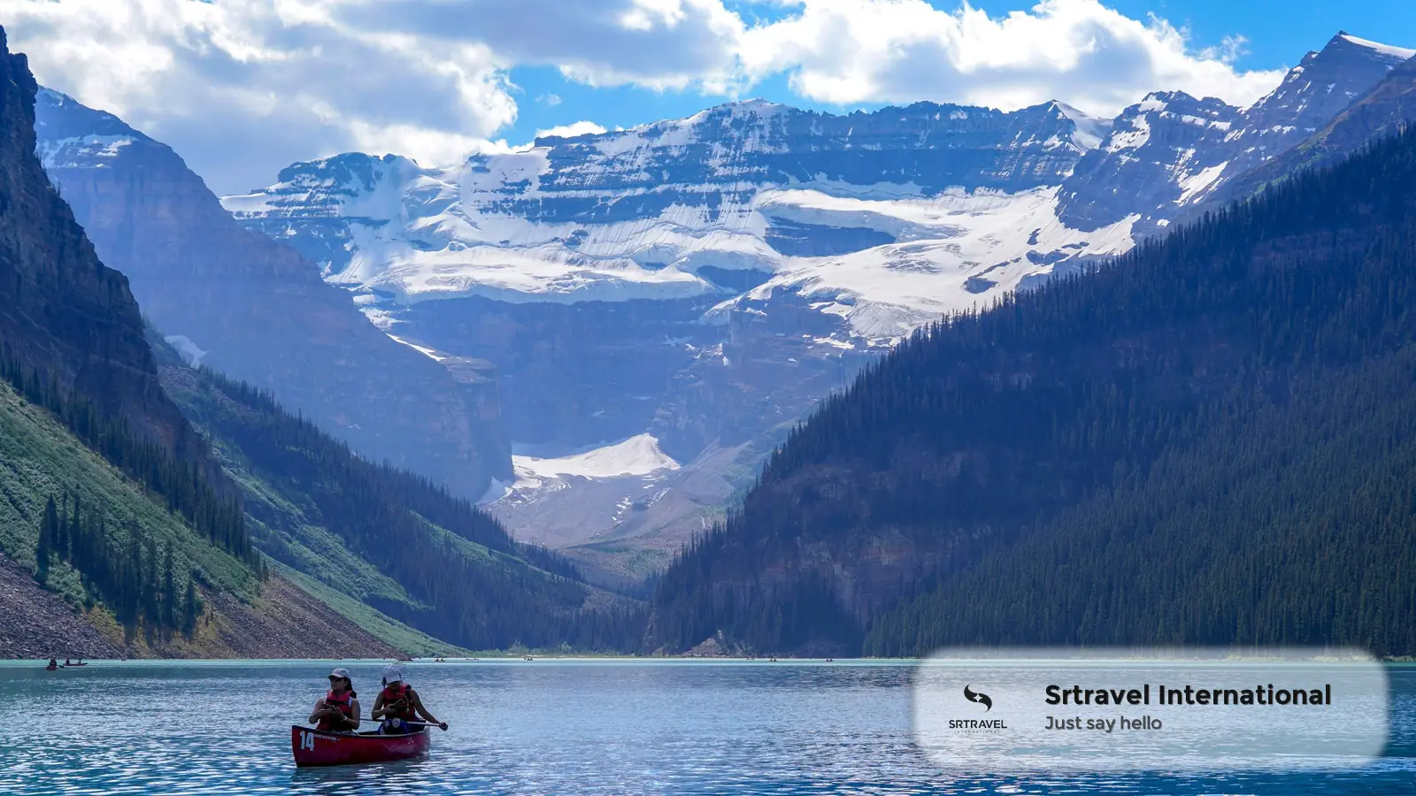 Hồ Lake Louise trong xanh bao quanh bởi núi tuyết ở Canada